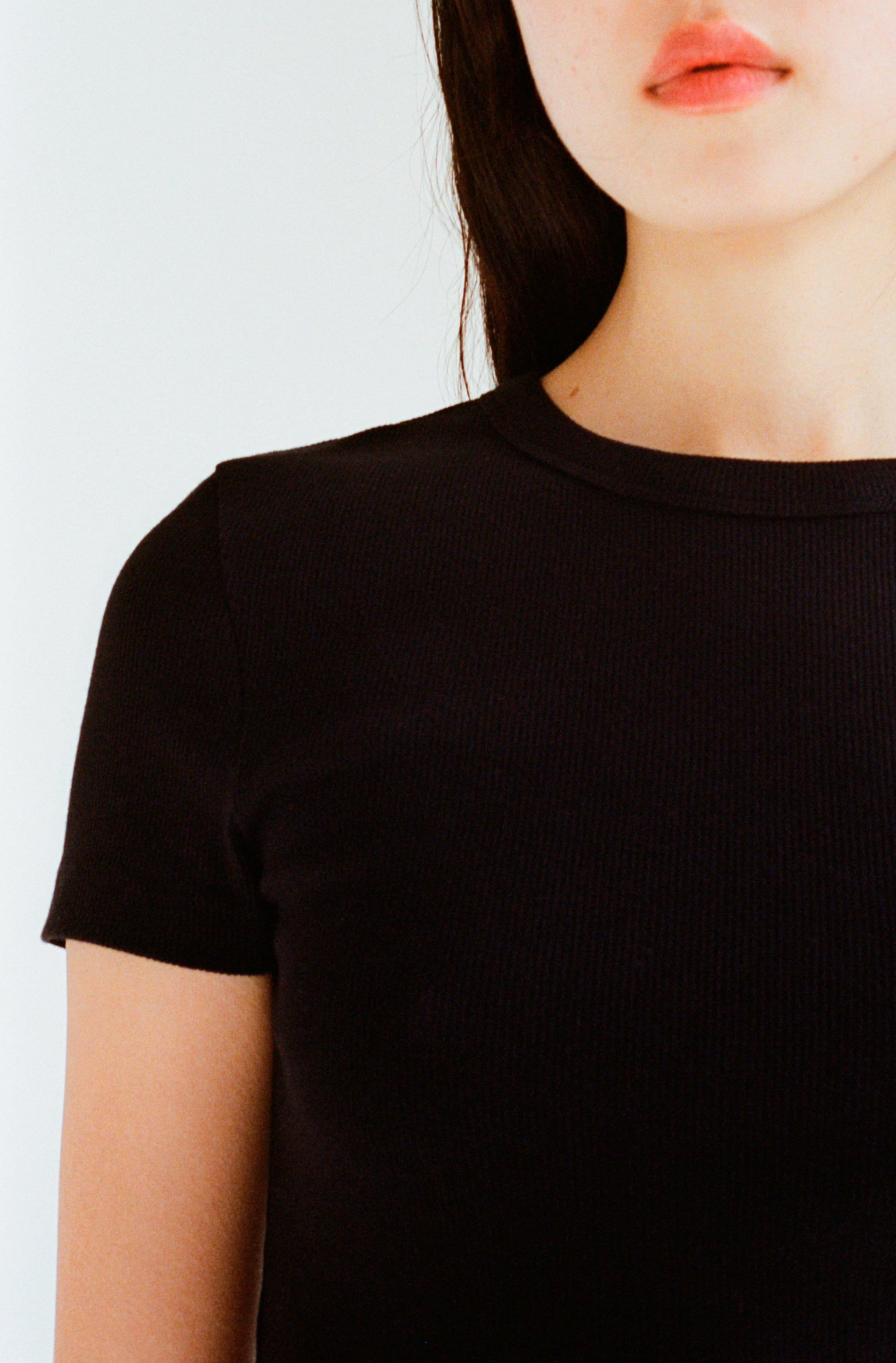 Le t-shirt à manches courtes noir pour femme en coton côtelé bio OMEAR, vue détaillée du col et d'une manche