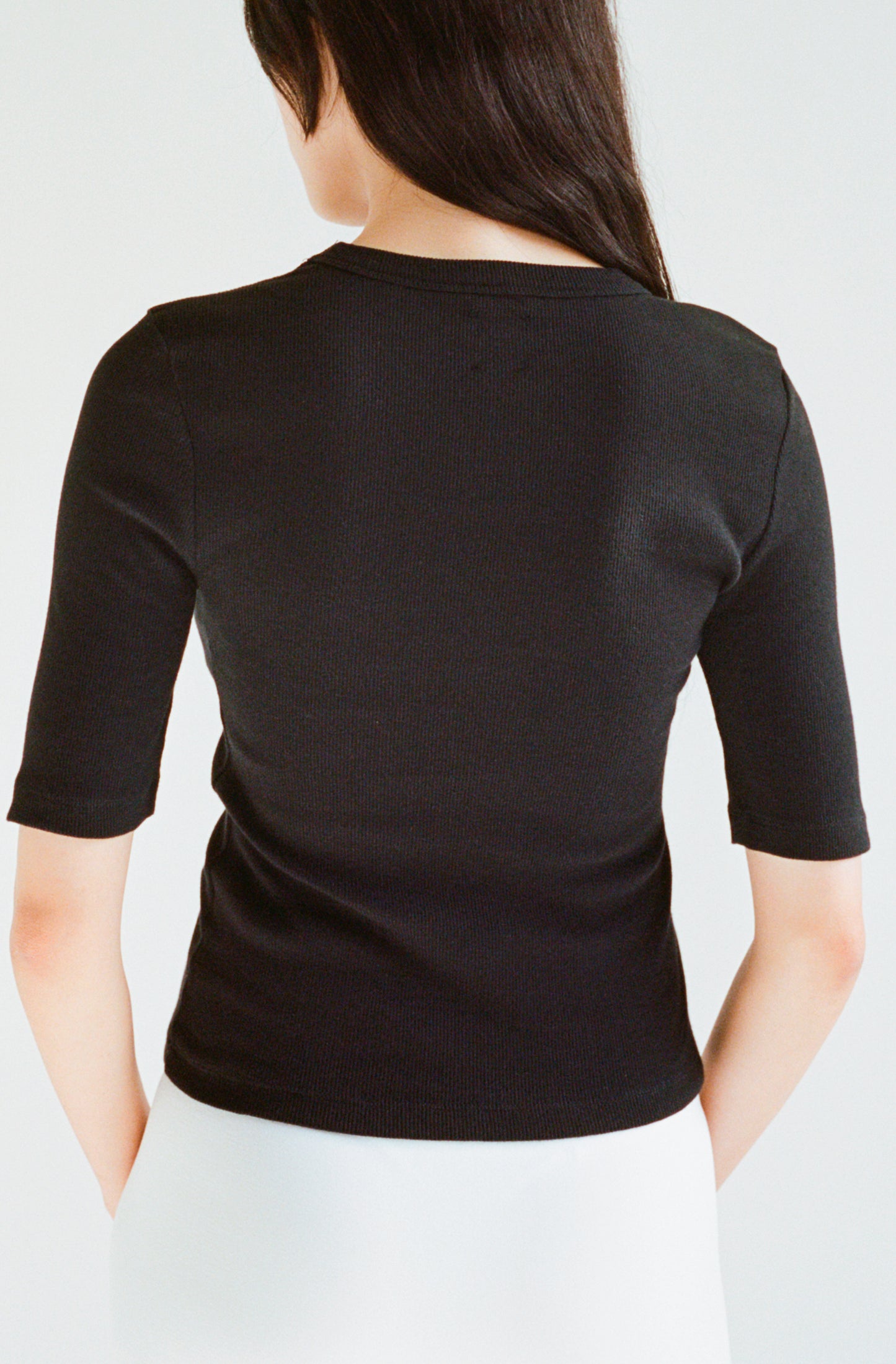 Le t-shirt noir à manches 3/4 femme en coton côtelé biologique OMEAR, vue porté de dos